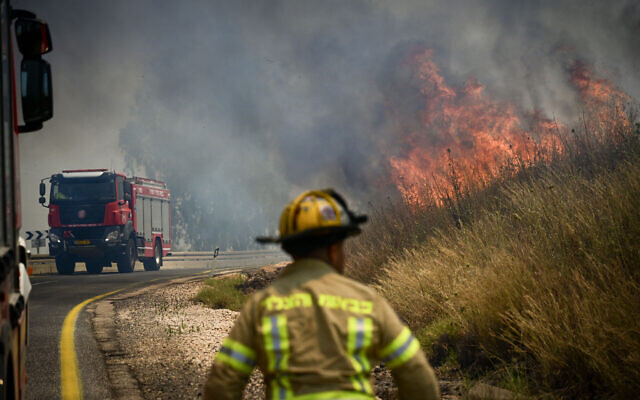 Israeli firefighters work to extinguish flames in the Golan Heights sparked by rockets fired from Lebanon, June 11, 2024. (Michael Giladi/Flash90) Israeli firefighters work to extinguish flames in the Golan Heights sparked by rockets fired from Lebanon, June 11, 2024. (Michael Giladi/Flash90)