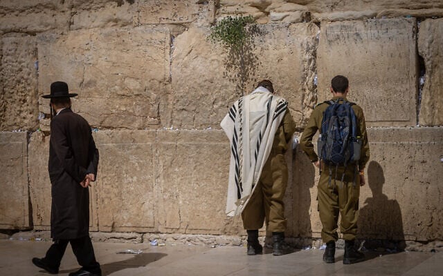 Israeli soldiers and an ultra-Orthodox man are seen at the Western Wall, in the Old City of Jerusalem, June 25, 2024. (Chaim Goldberg/Flash90) Israeli soldiers and an ultra-Orthodox man are seen at the Western Wall, in the Old City of Jerusalem, June 25, 2024. (Chaim Goldberg/Flash90)