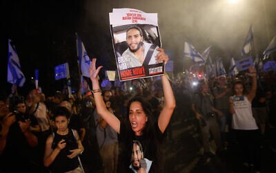 Einav Zangauker clutches a picture of her son, hostage Matan Zangauker, at an anti-government, pro-hostage deal rally on Jerusalem's Azza Street near Prime Minister Benjamin Netanyahu's residence, June 27, 2024. (Chaim Goldberg/Flash90)
