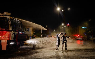 Police use a water cannon to disperse demonstrators during a protest against the recruitment of ultra-Orthodox Jews to the IDF, in Jerusalem, June 30, 2024. (Chaim Goldberg/Flash90)