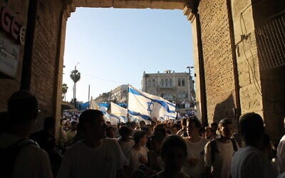 Right-wing Israelis march through the Damascus Gate into the Arab Quarter of the Old City of Jerusalem during the annual Jerusalem Day Flag March, June 5, 2024. (Sam Sokol/Times of Israel)