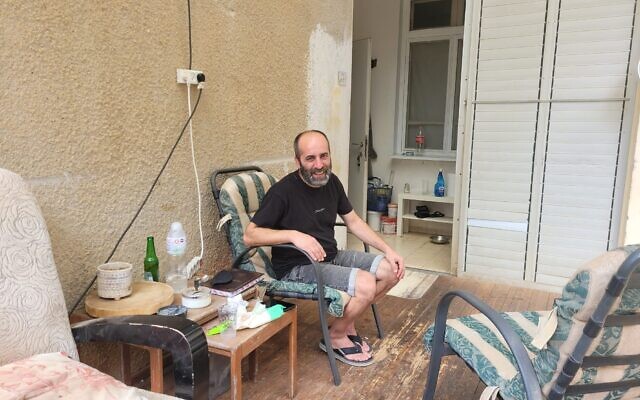 Asaf Ben Lulu sits at the entrance to his home in Eilon on June 9, 2024. (Canaan Lidor/Times of Israel)