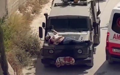 IDF soldiers tie injured Palestinian detainee to hood of car after an operation in the West Bank, June 22, 2024. (X, formerly Twitter, used in accordance with Clause 27a of the Copyright Law)