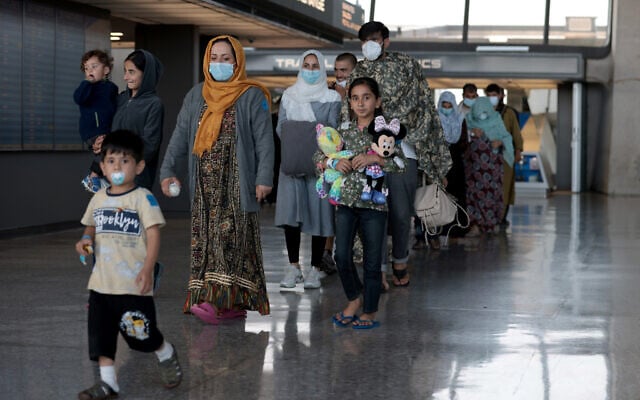 Illustrative: A family of people evacuated from Afghanistan is led through the arrival terminal at the Dulles International Airport to board a bus that will take them to a refugee processing center, in Dulles, Virginia, August 25, 2021. (Anna Moneymaker/Getty Images) Illustrative: A family of people evacuated from Afghanistan is led through the arrival terminal at the Dulles International Airport to board a bus that will take them to a refugee processing center, in Dulles, Virginia, August 25, 2021. (Anna Moneymaker/Getty Images)