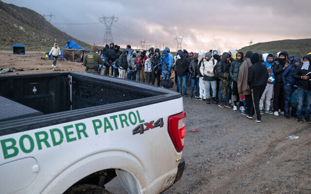 Illustrative - Asylum seekers wait in line to be processed by the Border Patrol at a makeshift camp near the US-Mexico border east of Jacumba, San Diego County, California, January 2, 2024. (Guillermo Arias / AFP)