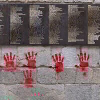 The "Wall of the Righteous" (Mur des Justes) outside the Shoah Memorial in Paris, France, is vandalized with red-hands graffiti, May 14, 2024. (Antonin Utz / AFP)