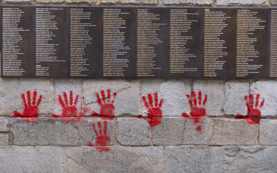 The 'Wall of the Righteous' (Mur des Justes) outside the Shoah memorial in Paris, France, is vandalized with red-hands graffiti, May 14, 2024. (Antonin Utz / AFP)