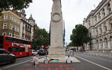 Youth Demand activists hold placards reading 'Stop arming Israel' and 'Never again for anyone' after laying flowers and a Palestinian flag at the Cenotaph war memorial in central London on July 15, 2024. (CARLOS JASSO / AFP)