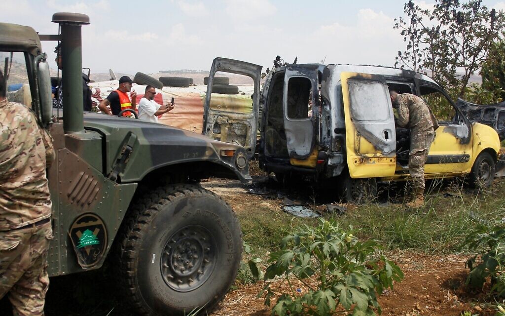Lebanese army soldiers check the wreckage of a car after a reported Israeli air strike targeted the area near the village of Borj al-Mlouk, some 18 km (11 miles) from the town of Nabatiyeh on July 20, 2024. (Rabih DAHER / AFP)