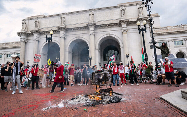 Pro-Palestinian, anti-Israel demonstrators stand near a burning grocery cart outside Union Station as they protest near the US Capitol as Israeli Prime Minister Benjamin Netanyahu addresses a joint meeting of Congress on July 24, 2024 in Washington, DC. (andrew thomas / AFP)