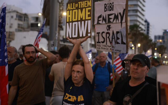 A woman holds a placard as families and supporters of Israeli hostages held by Hamas in the Gaza Strip since October 7, protest in front of the US Embassy branch office in Tel Aviv on July 24, 2024, in an attempt to pressure the Prime Minister Benjamin Netanyahu, ahead of his speech to the US Congress, to make a deal for their release. (Menahem Kahana / AFP)