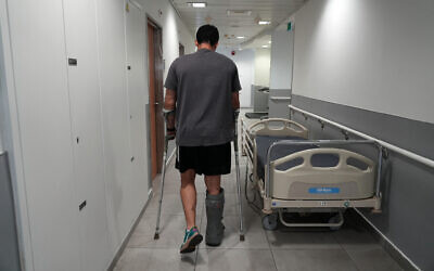 Barak, whose leg was shredded by a grenade during a failed hostage rescue mission in the Gaza Strip, walks along a corridor at the Ichilov Hospital in Tel Aviv, on July 22, 2024. (Sharon Aranowicz / AFP)