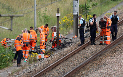 SNCF employees and French gendarmes inspect the scene of a suspected attack on the high speed railway network at Croiselles, northern France on July 26, 2024. (Photo by Denis CHARLET / AFP)