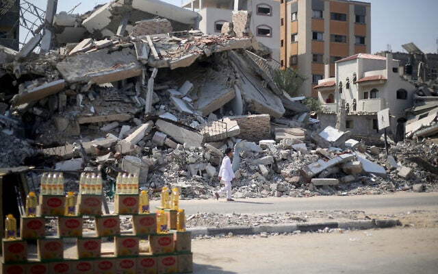 A man walks past a display of bottles set up by a vendor near buildings destroyed in a previous Israeli bombardment in Bureij, in the central Gaza Strip on July 28, 2024. (Eyad Baba/AFP) A man walks past a display of bottles set up by a vendor near buildings destroyed in a previous Israeli bombardment in Bureij, in the central Gaza Strip on July 28, 2024. (Eyad Baba/AFP)
