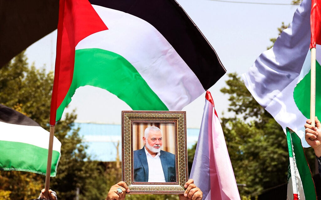 People hold up the Palestinian flag and a portrait of assassinated Hamas chief Ismail Haniyeh Hamas during a rally at Tehran University, in the Iranian capital Tehran on July 31, 2024, as Iran declares three days of mourning. (AFP)