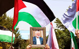 People hold up the Palestinian flag and a portrait of assassinated Hamas chief Ismail Haniyeh Hamas during a rally at Tehran University, in the Iranian capital Tehran on July 31, 2024, as Iran declares three days of mourning. (AFP)