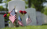 Illustrative — A display stands in front of the headstone of Robert L. Cotton, who served in the US Navy, in Fort Logan National Cemetery, Sunday, May 29, 2022. (AP Photo/David Zalubowski)