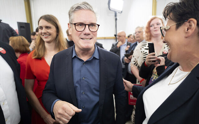 Labour Party leader Keir Starmer, center, leaves after addressing supporters during his visit to the West Regwm Farm Events Venue in Whitland, Carmarthenshire, while on the General Election campaign trail, in Wales, July 3, 2024. (Stefan Rousseau/PA via AP)