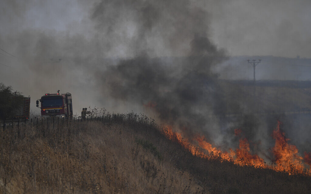 Firefighters work to extinguish a fire following an attack from Lebanese Hezbollah terror group, in the Golan Heights, July 4, 2024 (AP Photo/Gil Eliyahu)