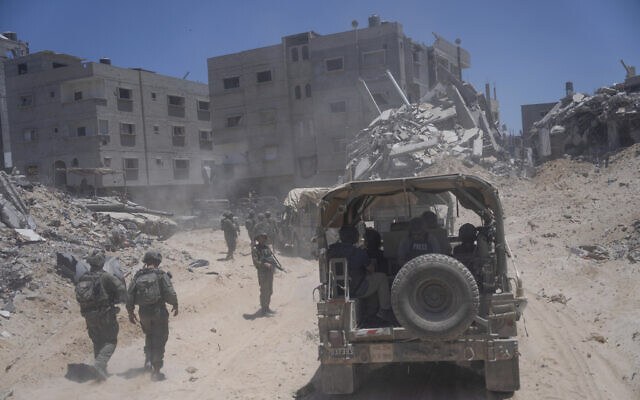 IDF soldiers walk in the southern Gaza Strip, July 3, 2024. (AP Photo/ Ohad Zwigenberg, Pool)