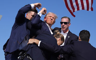 Presumptive Republican presidential candidate former president Donald Trump is surrounded by US Secret Service agents at a campaign rally, July 13, 2024, in Butler, Pennsylvania. (Evan Vucci/AP) Presumptive Republican presidential candidate former president Donald Trump is surrounded by US Secret Service agents at a campaign rally, July 13, 2024, in Butler, Pennsylvania. (Evan Vucci/AP)