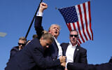 Republican US presidential candidate former president Donald Trump is surrounded by US Secret Service agents at a campaign rally after apparently being shot in his ear, July 13, 2024, in Butler, Pennsylvania. (AP Photo/Evan Vucci)