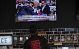 A person watches news in a local bar near the Fiserv Forum in Milwaukee ahead of the 2024 Republican National Convention, Saturday, July 13, 2024. Former president Donald Trump, bleeding from his ear, was whisked off the stage at a rally in Butler, Pennsylvania after an assassination attempt.(AP Photo/Matt Rourke)