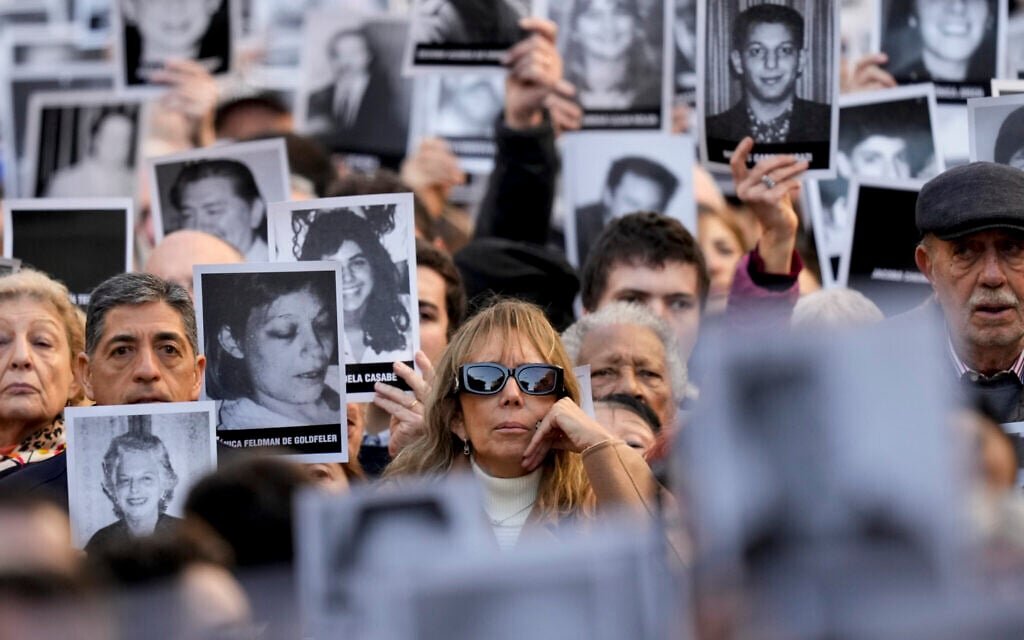 People hold photos of bombing victims as sirens blare during a ceremony marking the 30th anniversary of the bombing of the AMIA Jewish center that killed 85 people in Buenos Aires, Argentina, Thursday, July 18, 2024. (AP/Natacha Pisarenko) People hold photos of bombing victims as sirens blare during a ceremony marking the 30th anniversary of the bombing of the AMIA Jewish center that killed 85 people in Buenos Aires, Argentina, Thursday, July 18, 2024. (AP/Natacha Pisarenko)