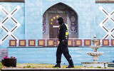 A police officer walks outside the Islamic Center Hamburg with the Imam Ali Mosque during a raid Wednesday, July 24, 2024, Hamburg, Germany. (Daniel Bockwoldt/dpa via AP)