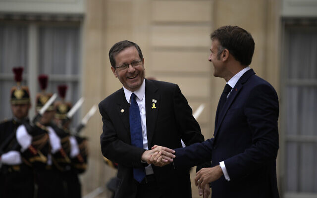 French President Emmanuel Macron, right, shakes hands with Israeli President Isaac Herzog after their meeting at the Elysee Palace, ahead of the opening ceremony at the 2024 Summer Olympics, Friday, July 26, 2024, in Paris, France. (AP Photo/Louise Delmotte)