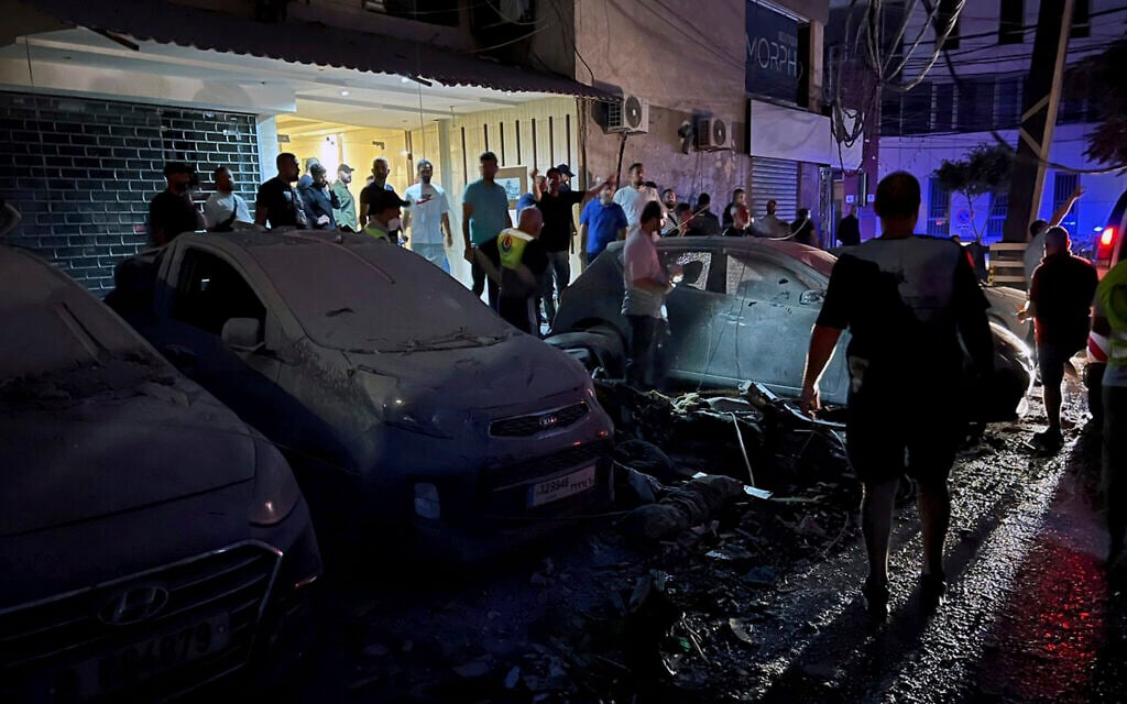 People inspect damaged cars in the southern suburbs of Beirut, Lebanon, July 30, 2024, after an Israeli airstrike hit Hezbollah's stronghold. (AP Photo/Hussein Malla)