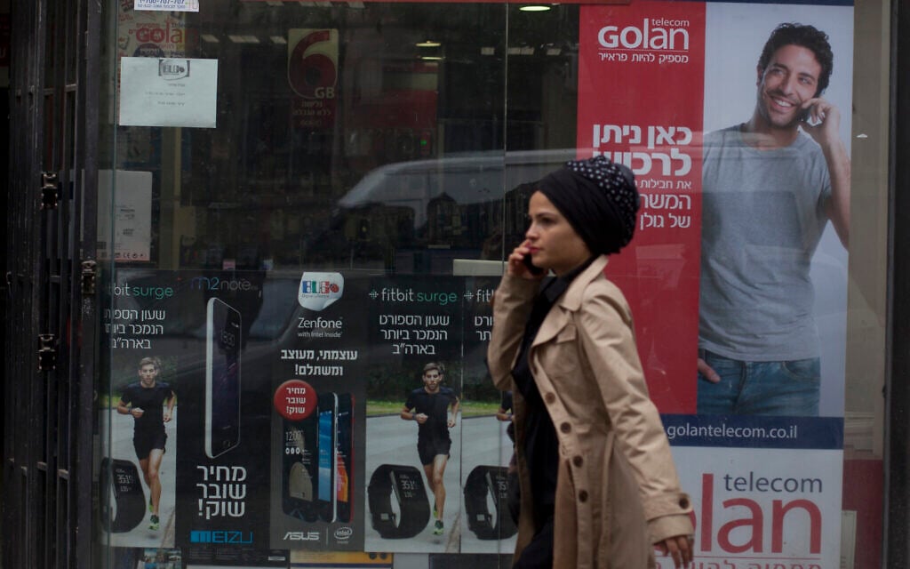 Illustrative: A woman walks next to an advertisement for Golan Telecom in Jerusalem, November 5, 2015. (Lior Mizrahi/Flash90) Illustrative: A woman walks next to an advertisement for Golan Telecom in Jerusalem, November 5, 2015. (Lior Mizrahi/Flash90)