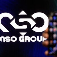 A man holds his phone with NSO GROUP logo on a computer screen in the background, in Jerusalem, on February 7, 2022. (Yonatan Sindel/Flash90)