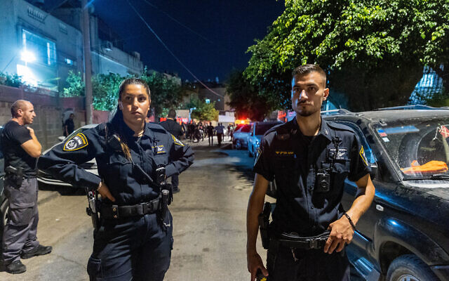 Police and medical personnel at the scene investigate the murder of a woman in her 30's that was shot dead, in Lod, July 26, 2022. (Yossi Aloni/Flash90)