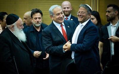 Prime Minister Benjamin Netanyahu, center, embraces National Security Minister Itamar Ben Gvir as ministers attend a meeting on the planned state budget, in the Knesset in Jerusalem, May 23, 2023. (Yonatan Sindel/Flash90)
