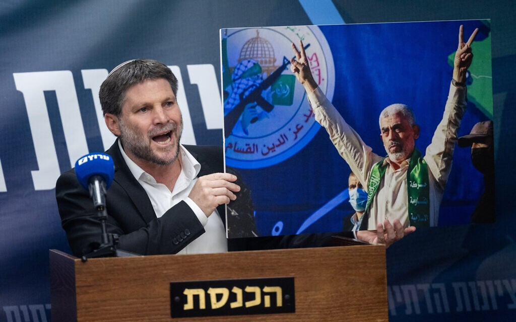 Finance Minister and head of the Religious Zionist Party Bezalel Smotrich holds up a picture of Gaza Hamas leader Yahya Sinwar while arguing against a ceasefire in Gaza during a faction meeting at the Knesset in Jerusalem, on July 8, 2024.(Yonatan Sindel/Flash90)