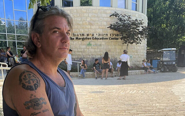 Lucas Cunio, older brother of hostages David Cunio and Ariel Cunio, with his freshly tattooed arm at an Artists 4 Israel event at Jerusalem's Botanical Gardens on July 7, 2024 (Jessica Steinberg/Times of Israel)