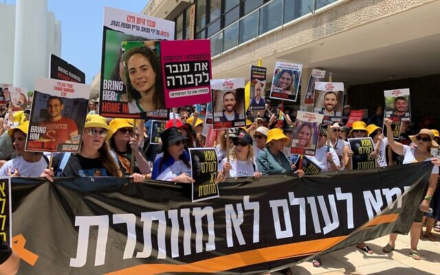 Protesters led by the mothers of Hamas-held hostages demonstrate in support of a hostage deal in Tel Aviv on July 5, 2024. The banner reads: A mother never gives up. (Charlie Summers/Times of Israel)