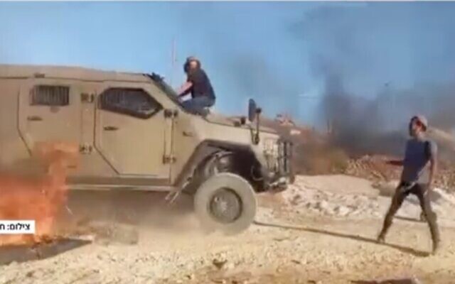Settlers attack Israeli forces demolishing an illegal outpost in the West Bank on July 3, 2024. (Screen capture/Channel 12)
