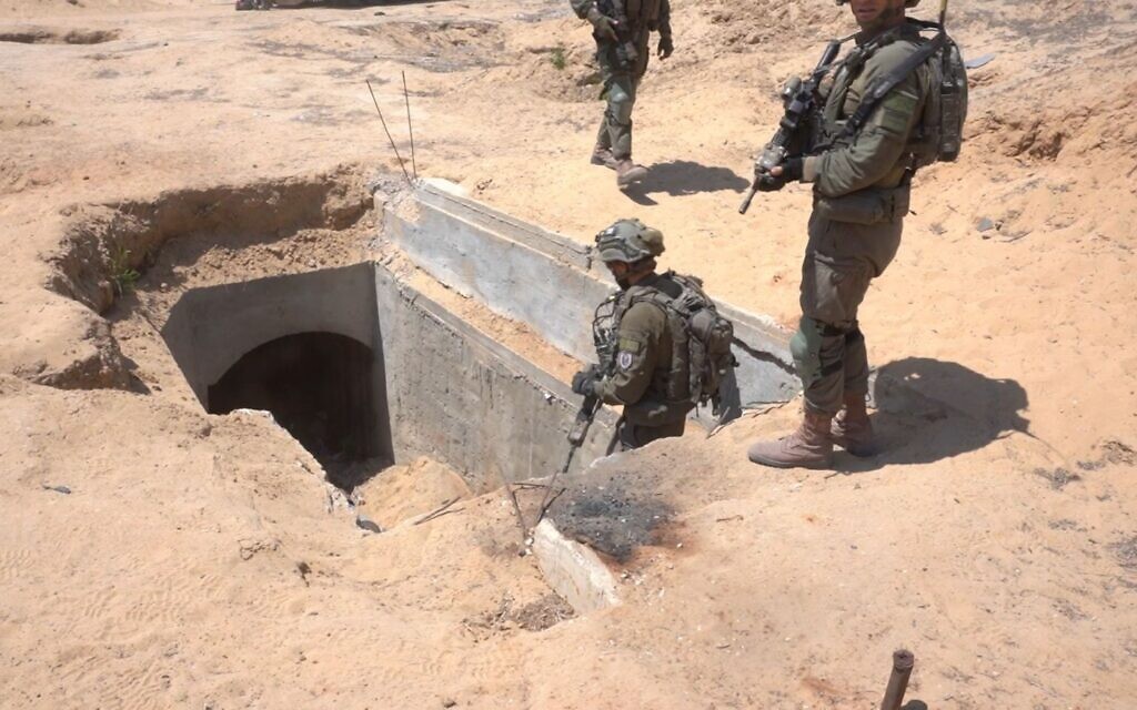 IDF troops stand at the entrance to a Palestinian Islamic Jihad underground rocket manufacturing site in southern Gaza's Rafah, in a handout image published July 1, 2024. (Israel Defense Forces)