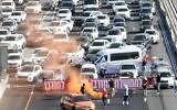 Protesters block Ayalon Highway with banner reading 'Enough of this destructive government' in Tel Aviv, July 4, 2024. (Aviv Atlas)