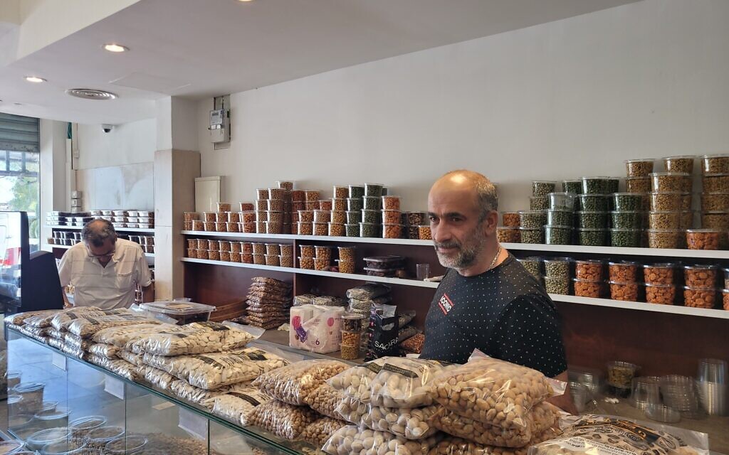 Haim Mergashvili speaks to a journalist at his store in Haifa on August 4, 2024. (Canaan Lidor/Times of Israel)