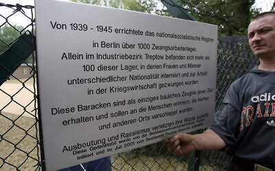 Illustrative: Workers put up a commemorative plaque outside barracks formerly used to house forced laborers now turned into a memorial and museum documenting Nazi Germany´s widespread use of forced labor in Berlin´s Schoeneweide district 24 August 2006. (Photo by JOHN MACDOUGALL / AFP)