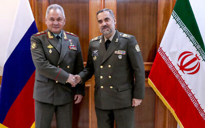 Russia's then-Defense Minister Sergei Shoigo (L) shakes hands with Iranian Defense Minister Mohammad-Reza Gharaei Ashtiani during their meeting in Tehran, September 20, 2023. (Iranian Defense Ministry / AFP)