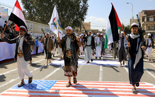 Armed Yemeni men step over a US and an Israeli flag painted on the asphalt in the Houthi-run capital Sanaa, during a march in support of the Palestinians, on February 29, 2024. (MOHAMMED HUWAIS / AFP) Armed Yemeni men step over a US and an Israeli flag painted on the asphalt in the Houthi-run capital Sanaa, during a march in support of the Palestinians, on February 29, 2024. (MOHAMMED HUWAIS / AFP)
