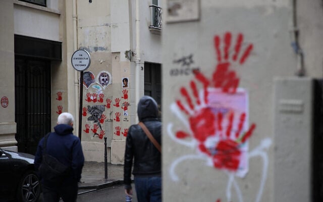 A picture shows red hand graffiti painted on buildings' walls of the Sainte-Croix de la Bretonnerie street, in the area where earlier the Holocaust memorial was vandalized with the same red handprints in Paris, on May 14, 2024. (Antonin Utz/ AFP) A picture shows red hand graffiti painted on buildings' walls of the Sainte-Croix de la Bretonnerie street, in the area where earlier the Holocaust memorial was vandalized with the same red handprints in Paris, on May 14, 2024. (Antonin Utz/ AFP)