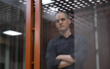 US journalist Evan Gershkovich, accused of espionage, looks out from inside a glass defendant's cage prior to a hearing in Yekaterinburg's Sverdlovsk Regional Court on June 26, 2024. (NATALIA KOLESNIKOVA/AFP)