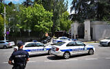 Police cars and officers are stationed on a street around the Israeli embassy in Belgrade, on June 29, 2024, after a man wielding a crossbow shot and wounded a police officer guarding the embassy, and was then fatally shot by the officer. (Oliver Bunic/AFP)