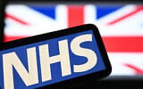 An illustration taken on July 7, 2024, shows the National Health Service (NHS) logo displayed on a screen backdropped by the Union Jack flag. (JUSTIN TALLIS / AFP)