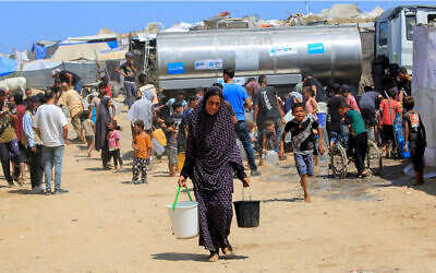 File: Palestinians collect water from a UNICEF tanker in Deir el-Balah in the central Gaza Strip on July 9, 2024. (Eyad BABA / AFP)